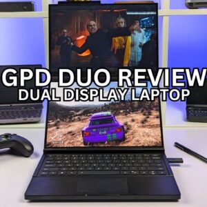 Esta imagen muestra un portátil de doble pantalla titulado &quot;GPD DUO REVIEW&quot;. El portátil presenta dos pantallas, una encima de la otra, en la que la superior muestra una escena de una película o programa de televisión, mientras que la inferior muestra un videojuego de carreras. El portátil tiene un teclado en la parte inferior, y hay un mando de juegos y un bolígrafo apoyados en la mesa de al lado. El fondo muestra una estantería con otros portátiles y aparatos tecnológicos. El logotipo del procesador AMD Ryzen 9 HX aparece en la esquina inferior derecha de la imagen.