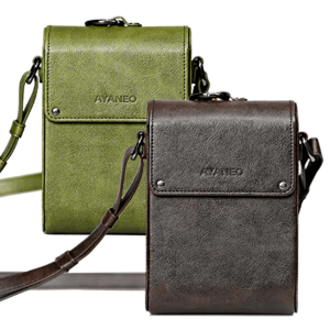 A side-by-side display of two AYANEO leather crossbody bags in green and brown. Both bags are minimalist in design, with embossed branding and adjustable straps.