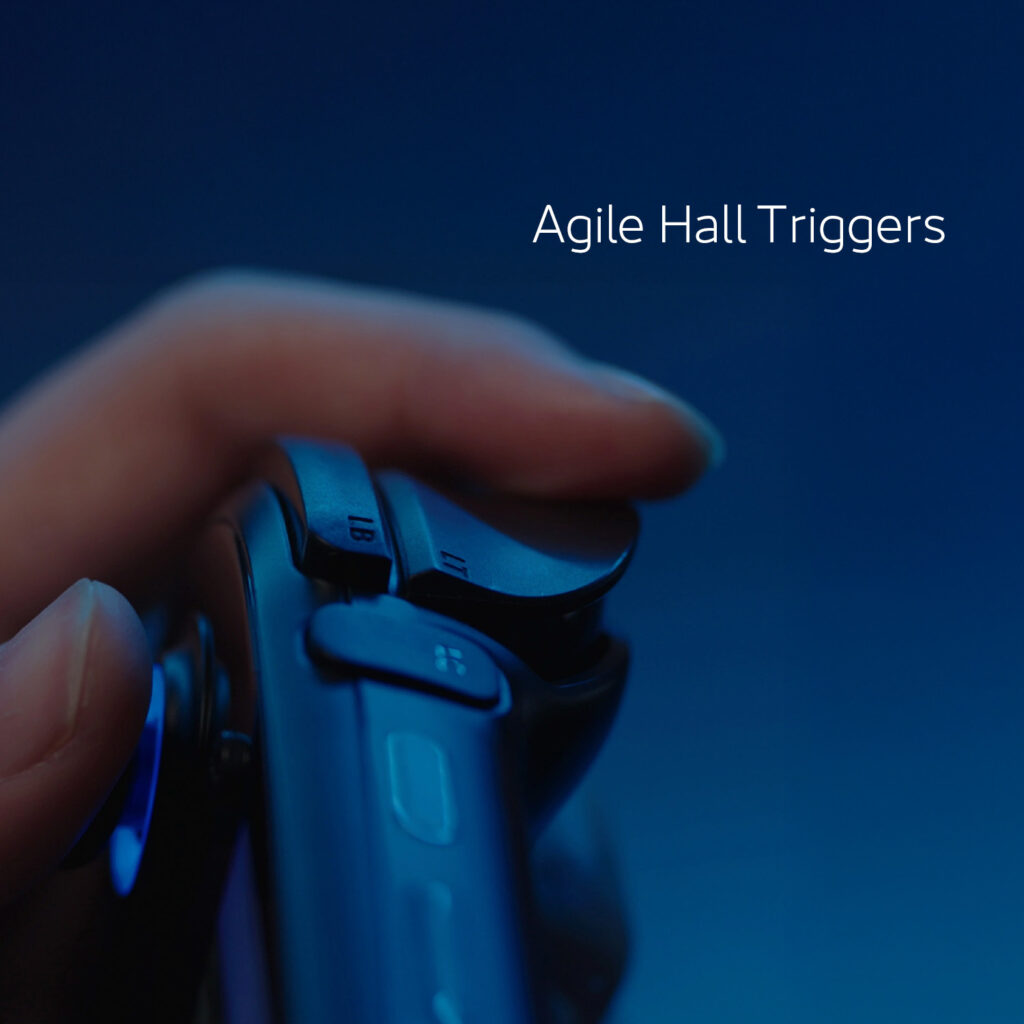 A close-up shot of a hand holding a dark-colored gaming controller or handheld device, specifically highlighting the shoulder trigger button. The image is bathed in a blue light, and white text at the top reads "Agile Hall Triggers."